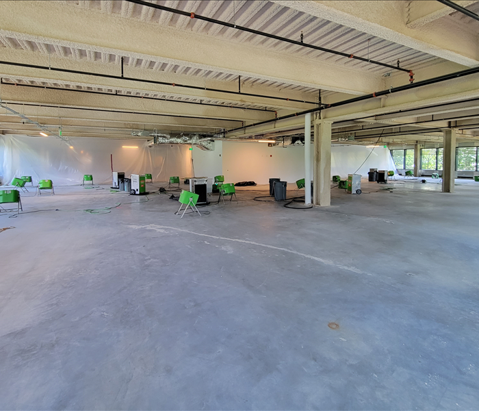 very large space under construction with many fans and dehumidifiers in it for drying 
