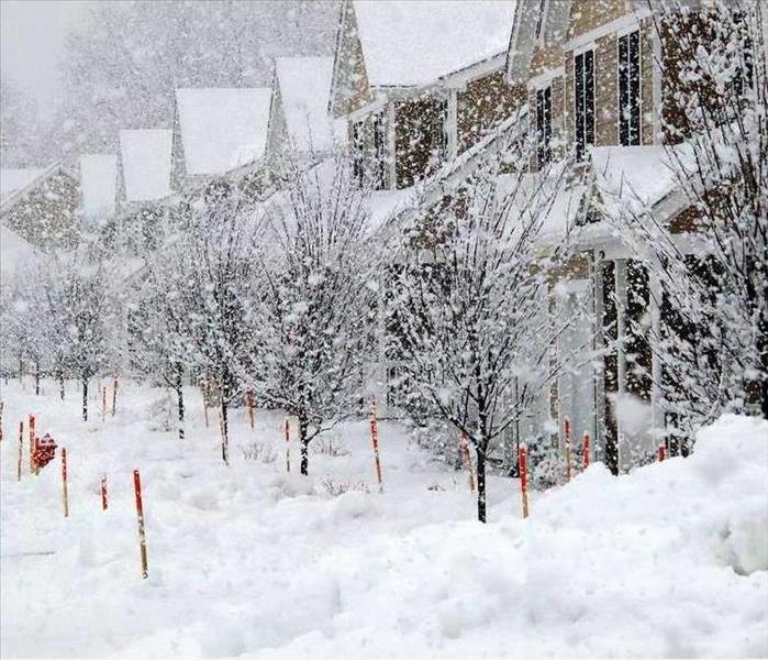 heavy snowfall on a street full of houses